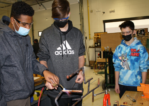 Three students welding