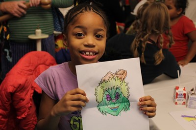 Little girl with her drawing of a Grinch.