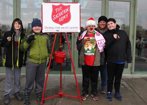 Group shot of four students ringing bells with teacher Kelly Scott.