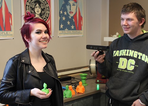 Two students with more 3-D printed sculptures designed by their class.