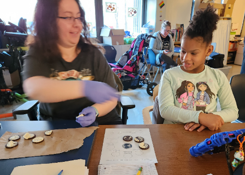 Teacher with student using cookies to demonstrate lunar phases