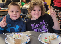 Two students with colorful edible gnome homes