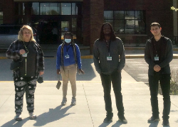 Four students in front of the Community Center