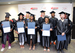 graduates posing in front of CWD backdrop