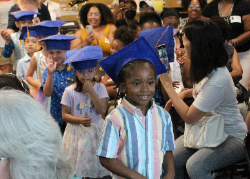 Preschoolers wearing graduation caps