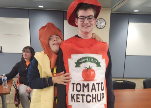 Two friends in costume: one a hot dog and the other a bottle of ketchup