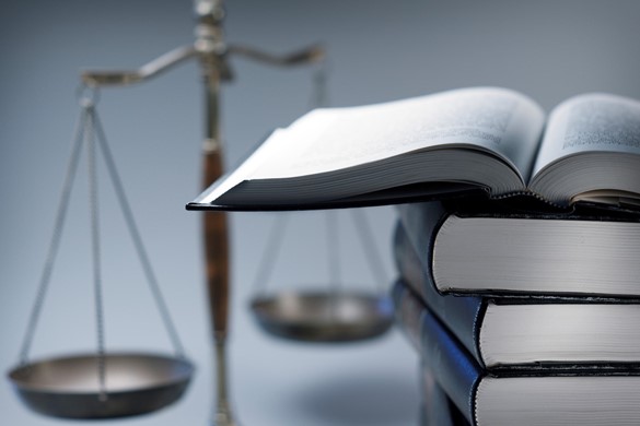 Stack Of Law Books In Front Of Scales Of Justice 