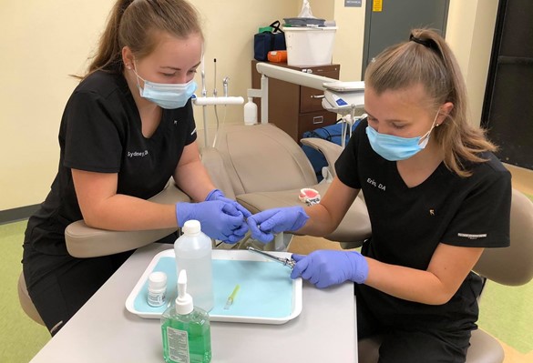 Two CTE students gloved and masked