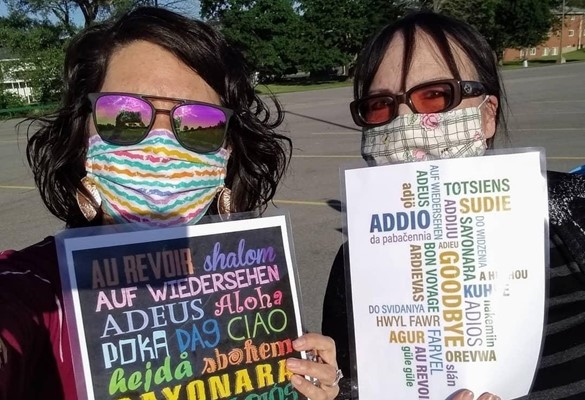 Teacher with signs wearing masks