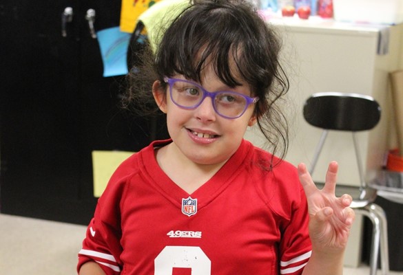 Student in red shirt giving the &#34;V for Victory&#34; sign