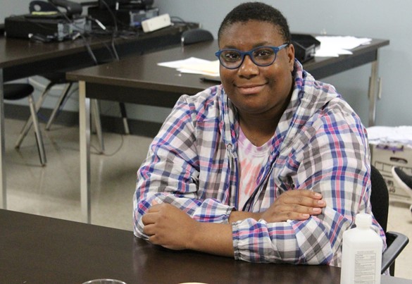 Smiling student wearing plaid shirt and blue glasses