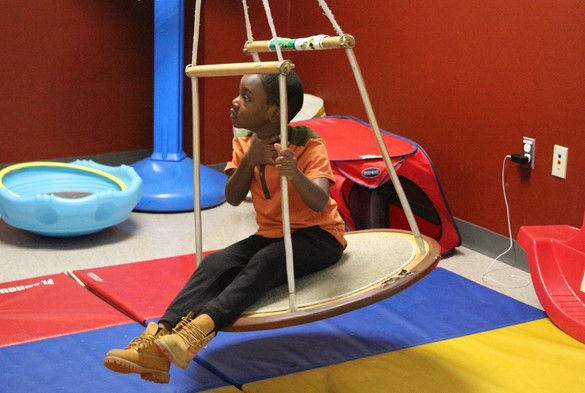 Preschool student sitting on swing