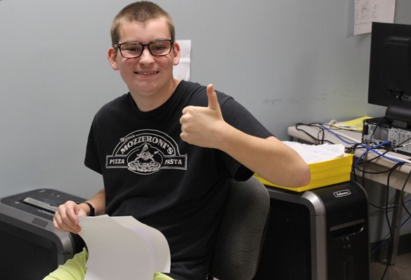 Student giving thumbs up sign and smiling