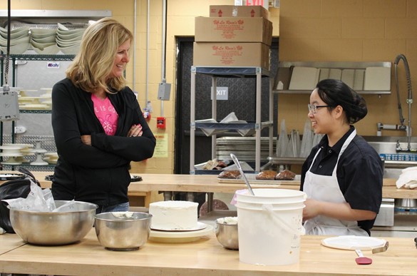 Two people laughing in a culinary class