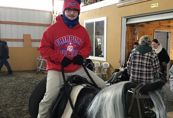 Student riding a horse on a field trip