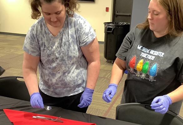 Student with instructor learning how to set a table