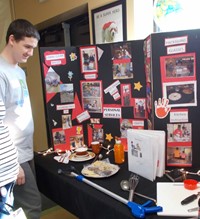 A student looks over a tabletop display of the areas of study in Personal Services