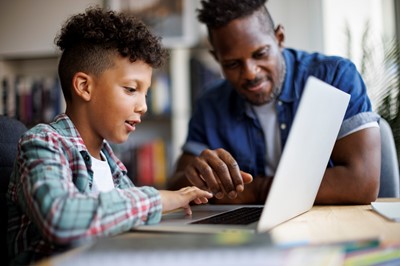 Student with parent working on computer at home