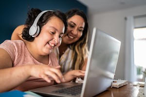 Student and parent working on a laptop at home